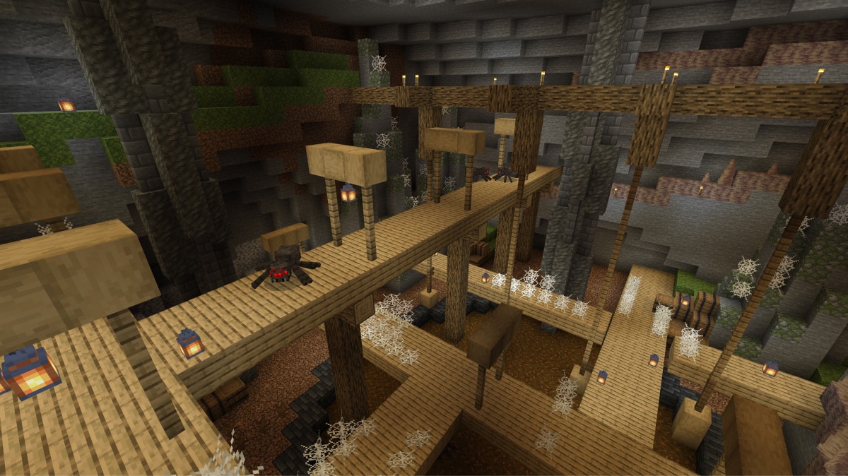 Atmospheric torch-lit cavern in Minecraft with strong shadows and depth